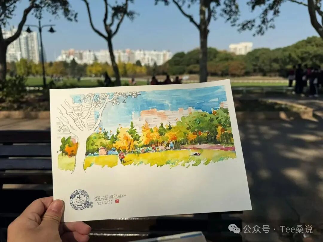 手持公园草坪与树木的水彩写生，背景是树荫和远处建筑